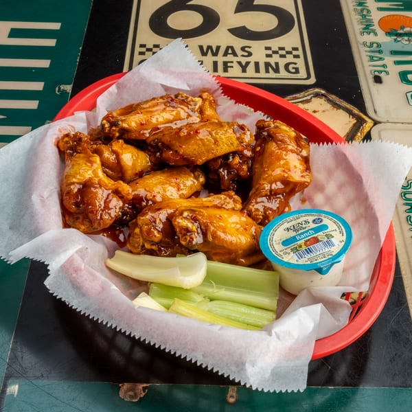 Nice N Easy Oyster Bar & Grille's chicken wings in a red basket with celery and ranch dressing.
